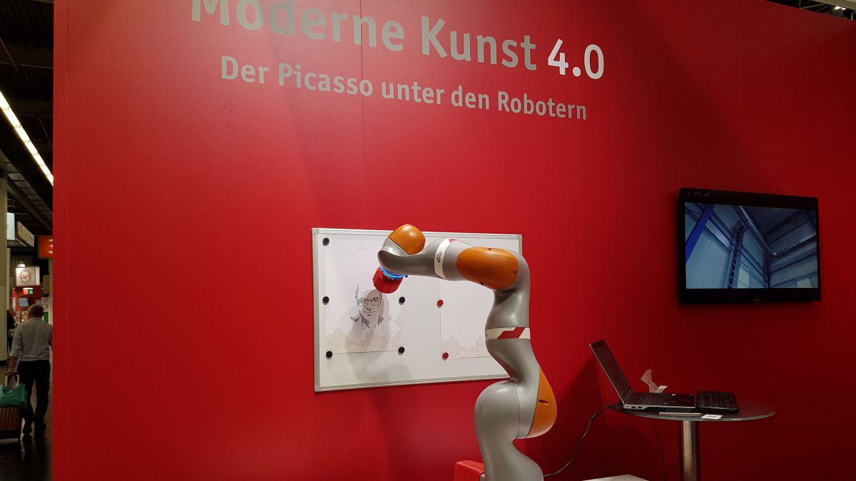 Auf dem Bild sieht man einen Roboterarm, der ein Gesicht zeichnet.