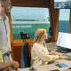 Drei Personen in einem Kontrollraum der Schifffahrt, sie schauen auf einen Monitor